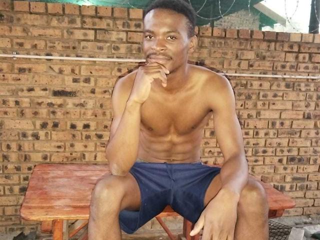 Digital illustration of a stylized coat of arms with a central red and blue diamond, flanked by white and black vertical stripes. Simple, bold colors and clean lines.