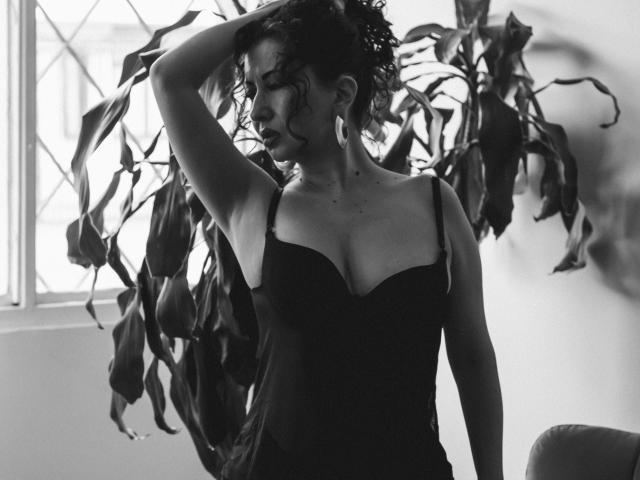 Close-up of a modern, minimalist logo with bold, white letters "V" and "L" in the center, set against a pale beige background. Clean, flat design with strong contrast.