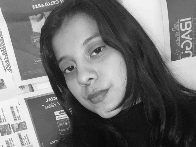 Black and white selfie of CoralineHale with long dark hair, nose ring, and pouty lips, wearing a turtleneck. Her boobs are not visible, just her face.