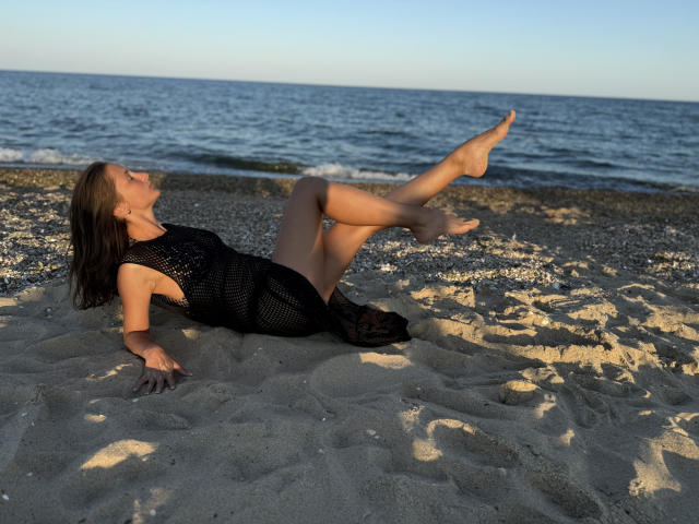 Digital illustration of a sword with a dark, textured blade and ornate hilt, positioned vertically. Orange and black accents on the hilt, with a subtle metallic sheen.