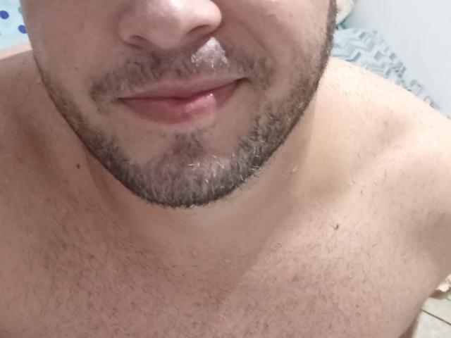 Palcheco69's upper body, showing a hairy chest and a slight beard, with parted lips and a subtle smile. His nose and lower face are visible.