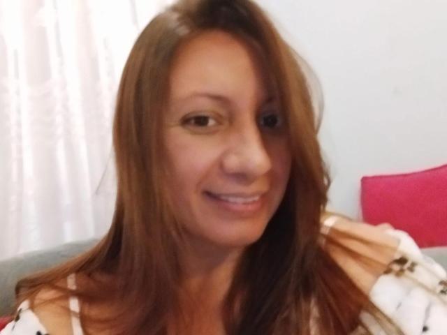 Britney69 has brown hair, a cute smile, and small tits. She's wearing a white and brown striped top. Her nose is small and her skin is light.
