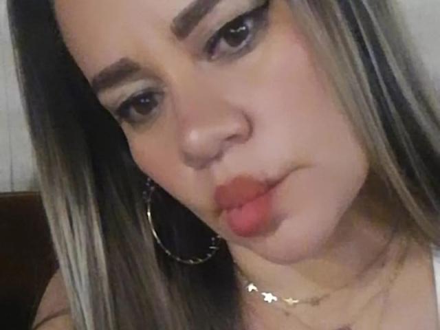 CharllotI has pouty pink lips, slightly upturned nose, and is making a "pooch" face with her mouth closed. She has long blonde hair, hoop earrings, and subtle makeup.