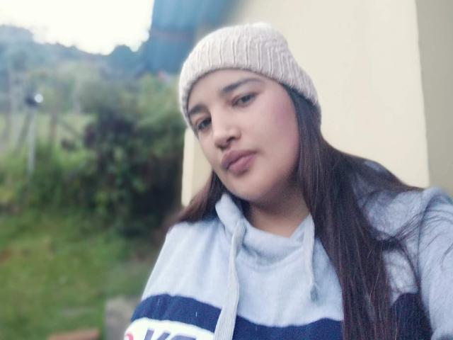 ZafiRouge has long brown hair, wearing a beige knit beanie and a blue and white striped sweater, with pouty lips and a slightly bluish-grayish skin tone.