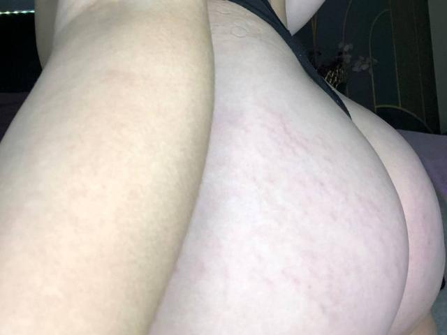 Les fesses pâles et légèrement abîmées de MonAmourR, en sous-vêtements noirs, avec un gros plan de leurs fesses nues et galbées, et une marque d'étirement visible sur la fesse droite..