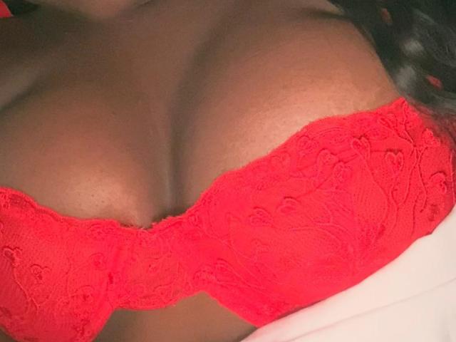 SweeterChocolate's big, red lace bra is showing off her large, round tits. The bright red lace is detailed with floral patterns, highlighting her dark skin.