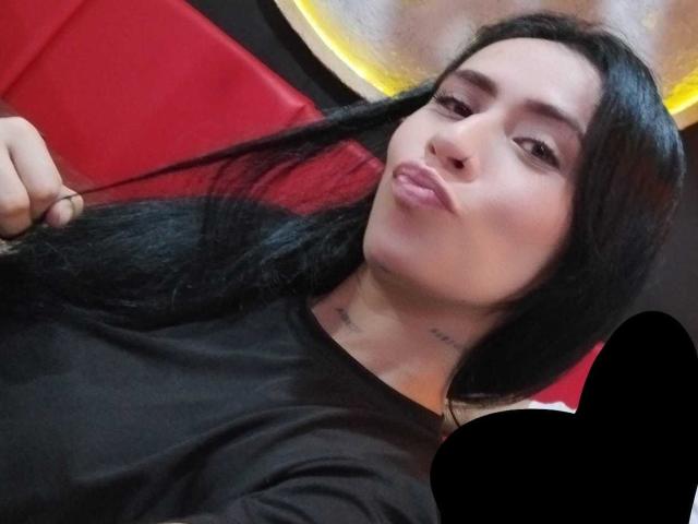 AlexaRosex has long black hair, pouty pink lips, and a black shirt. She's pulling her hair with a tattoo visible on her neck. Red background.