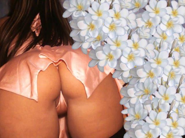 As nádegas de Monellina, em seda rosa, com as bochechas expostas, e um conjunto de flores brancas de plumeria à direita. Seu cabelo castanho é visível acima da seda..