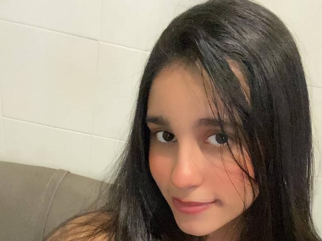 Digital art of a stylized, minimalist letter "V" in red and pink. Simple, bold lines, flat colors. Centered, slightly tilted. No gradients, shadows. Clean, modern design.