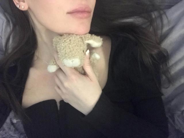 LiliaRose-hot's face is partially visible, holding a beige stuffed monkey against her chest. She has pale skin, dark hair, and wears a black top, with her hand on her tits.