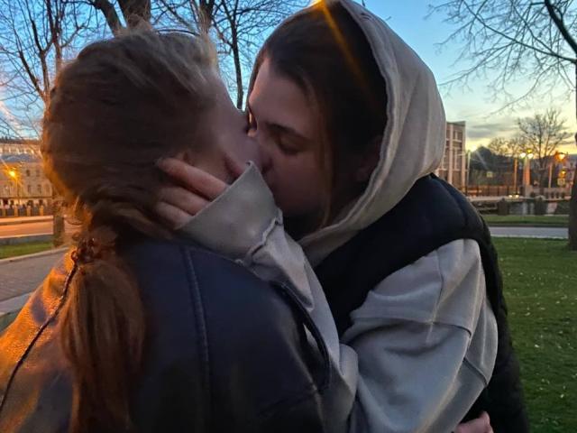 Graphic with a bold, flat-style design. Central red emblem resembling a simplified letter "A" or "a". IngaFoxy's figure is not visible. Colors: red, white, blue. Minimalist, geometric.