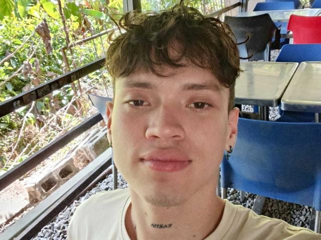 YimbersonPetterX tiene el pelo corto, castaño y rizado, ojos marrones, piel clara, pequeños pendientes negros y una camiseta blanca. Su rostro tiene un ligero vello incipiente y un pequeño tatuaje debajo del mentón..
