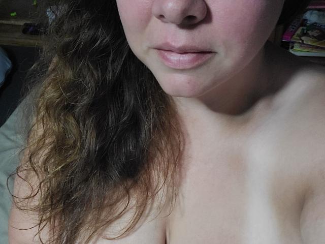 SexyTimeBBW has pale skin, curly brown hair, and is topless with visible tits and pink nipples, showing a neutral expression with slightly parted pink lips.