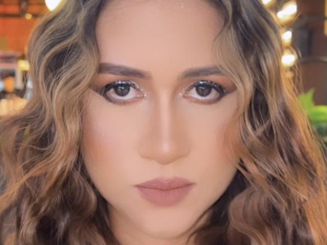 TiaraEvans has wavy brown hair, subtle makeup, and full, pinkish-brown lips. Her brown eyes are centered and slightly upturned. She's looking directly at the camera.