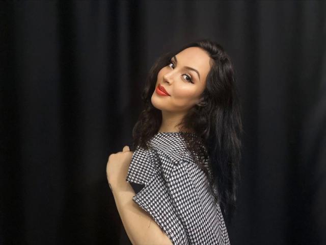 A digital image of a carved wooden shield with a geometric pattern, positioned in front of a large, stylized emblem. The emblem has a warm, orange light source.