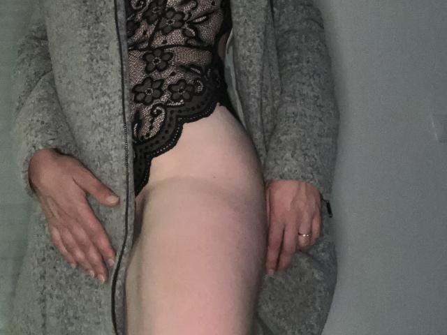 GlemaS with pale skin, wearing black lace lingerie, gray cardigan, and no pants, lying down, hands on thighs, showing bare ass and upper leg.