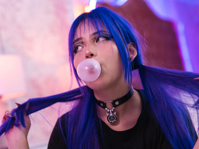 AmeliaXWalker with blue hair, blowing bubble gum, wearing a black choker with a metal ring, holding hair, looking up, in a photo with purple and pink lighting.