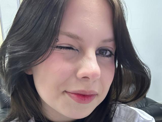 RenataSweety ha i capelli neri, un piercing al naso ed è ammiccante con un occhio. Ha le guance rosate, le labbra rosse e sta sorridendo leggermente. I suoi glutei non sono visibili..