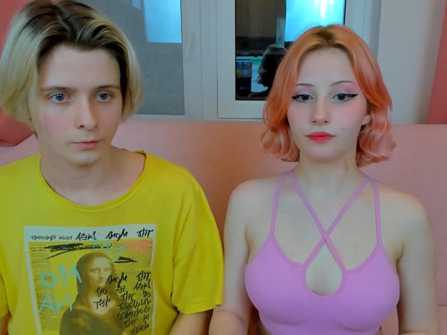 Michelle ha un taglio di capelli corto rosa e trucco, indossa una maglietta rosa con un taglio che lascia intravedere piccoli seni. James ha i capelli biondi, una camicia gialla e occhi azzurri, e sembra serio..
