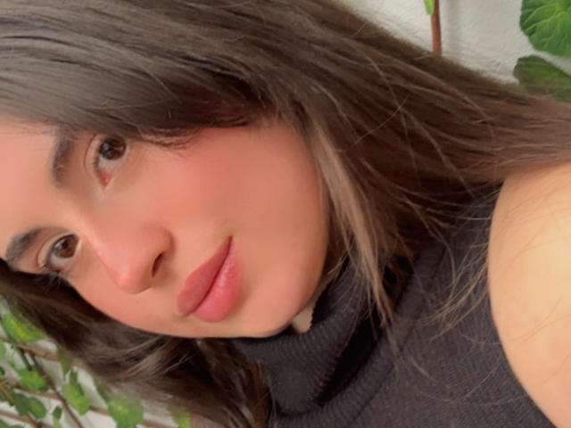 VicluX has medium brown eyes, slightly wavy dark brown hair, pinkish lips, and a light tan complexion. Wearing a black turtleneck, VicluX's face is centered in the image.
