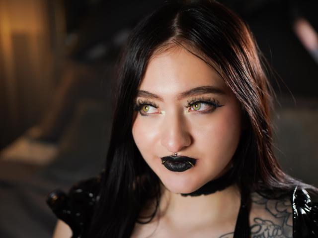 MagicCleo heeft bleke huid, groene ogen, zwarte lipstick, een neusring en lang zwart haar. Ze draagt een zwarte choker en een glanzend zwart top met tatoeages..