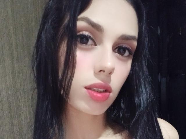 AnaisHilton with wet black hair, pink lipstick, and brown eyes, looking at the camera with slightly parted pink lips, her face centered in the image.
