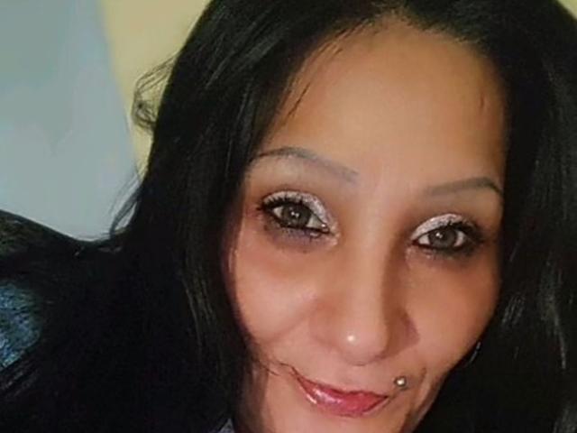 Brighy with dark hair, brown eyes, and a smile showing a pierced nose, wearing white eye makeup, and pink lipstick. Boobs not visible. Ass not visible. Tits not visible.