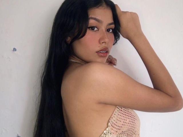 KinkyCuteLady with long black hair, brown eyes, and pink lipstick, looking over her shoulder, hand in hair, wearing a strapless pink crochet top, showing her tits.
