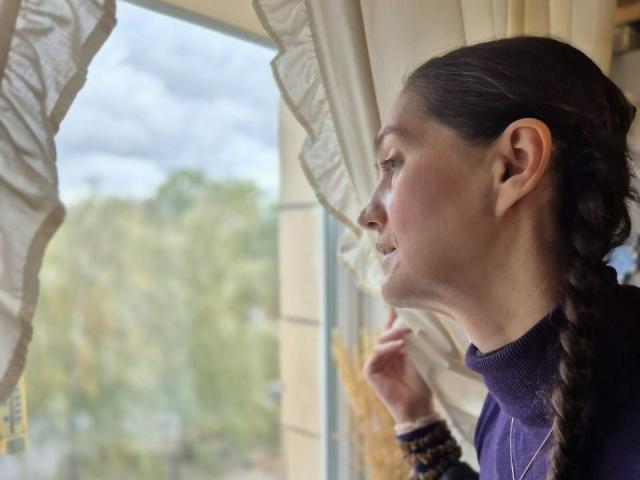 TayaFlavy's profile shows her with braided brown hair, wearing a purple turtleneck, leaning on a window with ruffled curtains, smoking a cigarette.