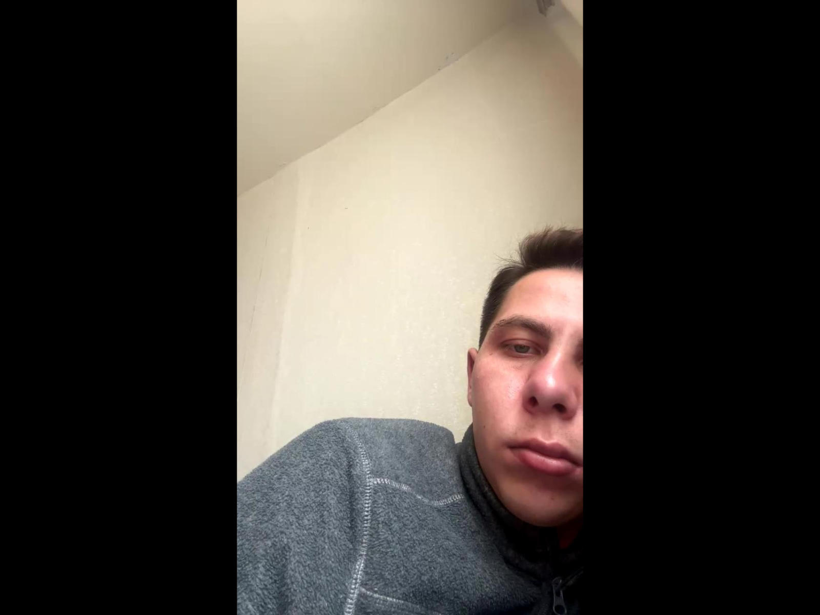 GeraldyInsky69, a chubby dude with short brown hair, wearing a gray zip-up, has a serious face in a selfie. His nose and upper lips are slightly visible.