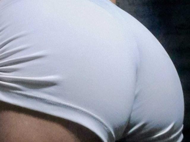Le short blanc, moulant et ajusté, met en valeur les fesses rondes et fermes de DomiEvans. Le tissu est légèrement froissé, ce qui accentue la forme de ses fesses. La peau est visible en bas..