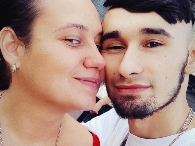 Charlotte y James tienen las narices casi tocándose. Los pechos de Charlotte son ligeramente visibles debajo de una blusa roja, mientras que James tiene barba y cabello negro corto, y lleva una camisa blanca..