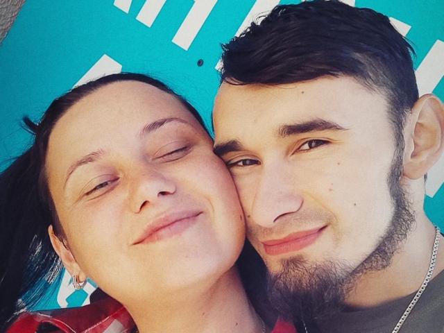 CharlotteAndJames' faces are close, smiling, with her eyes half-shut and his beard against her bare skin, both with dark hair, her nose slightly above his. She's wearing a red shirt.