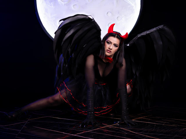 ElizabethDupont with black wings, red horns, and black dress, crouching on grid, red lines, black gloves, and stockings, moon in background, looking sexy and seductive.