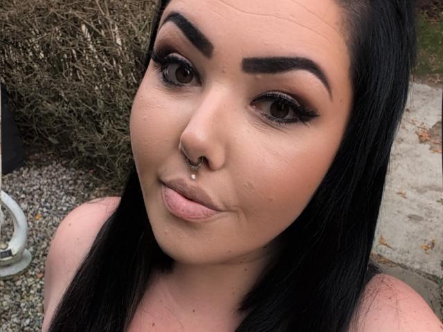 OoBonnieoO has dark black hair, brown eyes, thick eyebrows, a septum piercing, and is puckering her lips. She's wearing makeup with long lashes. Her skin is light.