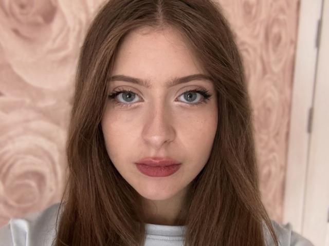 Palerianna ha gli occhi azzurri, i capelli lunghi castani e indossa un rossetto rosso. Guarda direttamente l'obiettivo con un'espressione neutra. Il suo seno non è visibile..