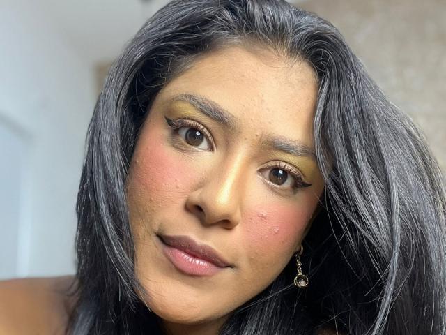 Babilett heeft een medium bruine huid, zwart haar, gele oogschaduw, bruine eyeliner, roze blush en glanzende roze lippenstift. Ze draagt een kleine gouden oorbelle. Haar gezicht is lichtelijk rood..