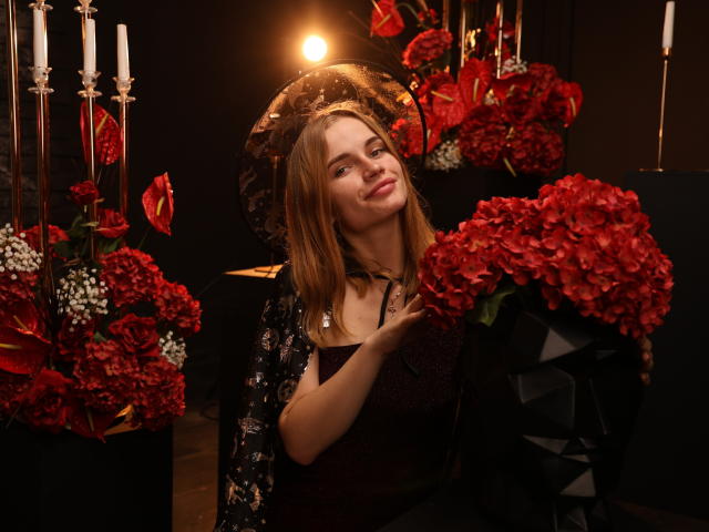 MargaritaKis with red roses, black dress, and lace headpiece, touching her tits, smiling, holding a large bouquet, candles in background, dim light, elegant, sexy.