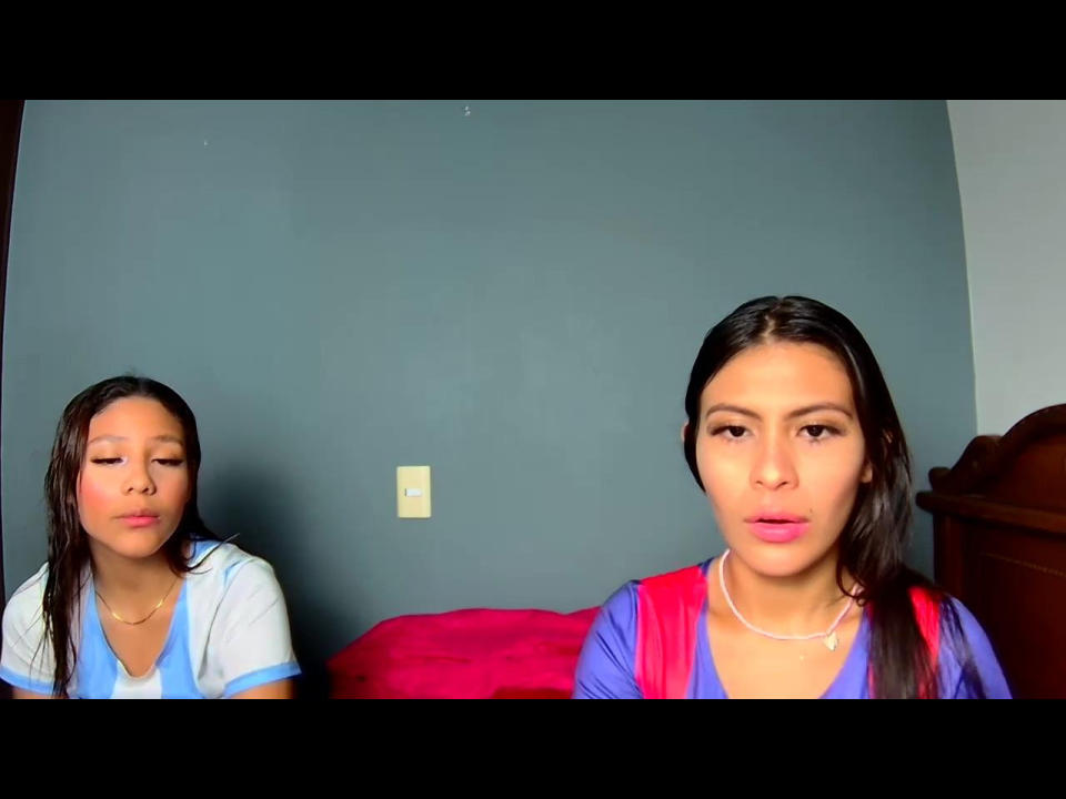 KathyViolet with wet brown hair, pouty lips, wearing a blue and white top, sits left. KathyViolet, with pink lipstick, brown eyes, wearing red and blue top, sits right.