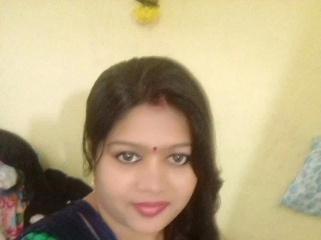 Nehaaahire-hot has dark hair, brown eyes, and a small red bindi on her forehead. She's smiling with pink lipstick, wearing a dark top, and has a cute face.