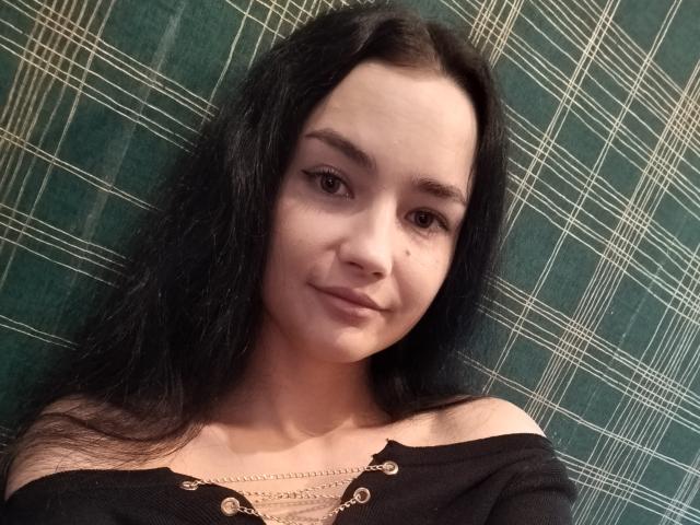 TishaUrsa ha lunghi capelli neri, occhi marroni e un leggero sorriso. Indossa una maglia nera con una spalla scoperta, con bottoni dorati e una catena. Il suo seno è piccolo..