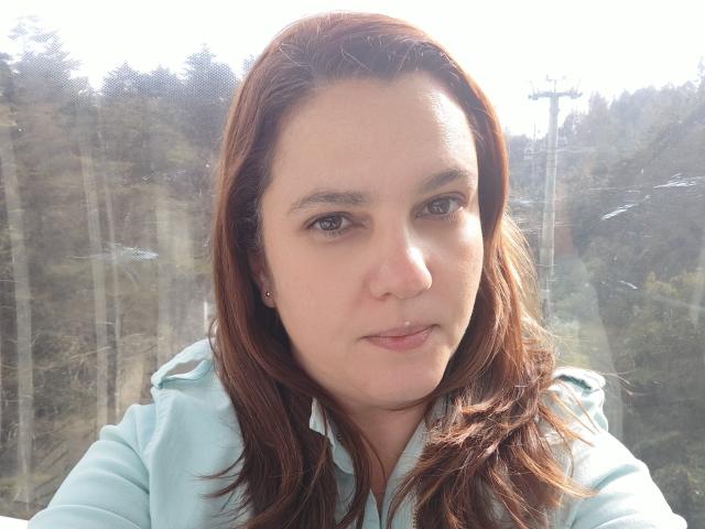 AmeliaWilson has brown hair, light skin, brown eyes, and a subtle smile. She wears a light blue hoodie, looking at the camera. Her nose has a small piercing.