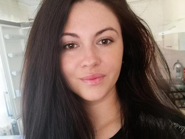 Fortune a de longs cheveux bruns foncés, des yeux marrons et des lèvres rosées. Elle porte un haut noir, et son visage est au centre de l'image avec un léger sourire..