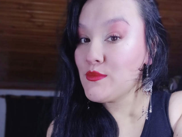 NuahElectra ha la pelle chiara, i capelli neri e ondulati, il rossetto rosso e indossa un ombretto rosso con un fard rosa, oltre a orecchini d'argento pendenti. Il seno è parzialmente visibile..