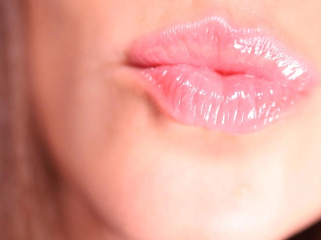 AuroraStar's shiny pink puffy ass-kissing lips, slightly parted, with glossy texture and subtle pink lipstick, centered in the frame.