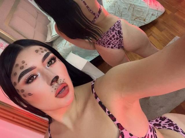 MaddisonCarter with leopard print bikini, showing her ass in the mirror selfie. She has black hair, face paint with spots, and red lipstick. Her tits are small, brown skin.