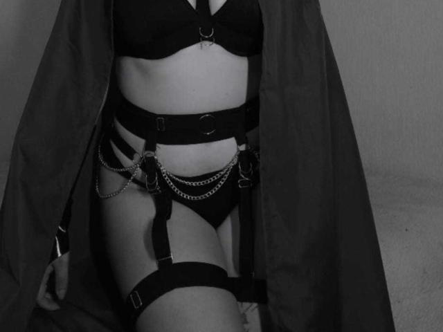JeneKurz in black lingerie with straps, chains, and a garter, wearing an open dark robe, showing their bare tits and pussy. Black-and-white, sexy, and seductive.