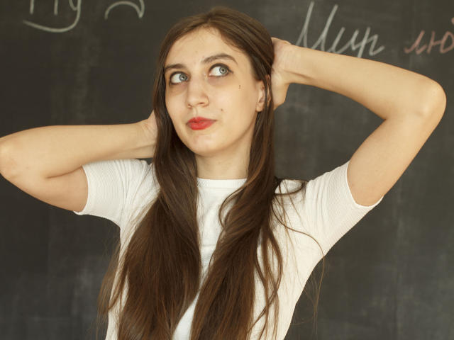 SummerCathy has long brown hair, blue eyes, and red lips, wearing a white shirt with arms raised, hands behind head, looking slightly to the side with a pouty expression.