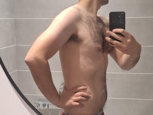 Paul69 est torse nu, montrant une poitrine poilue, de petits tétons et un profil légèrement corpulent, avec des fesses poilues, sur une photo prise dans un miroir. Il tient un téléphone, qui lui couvre le visage..