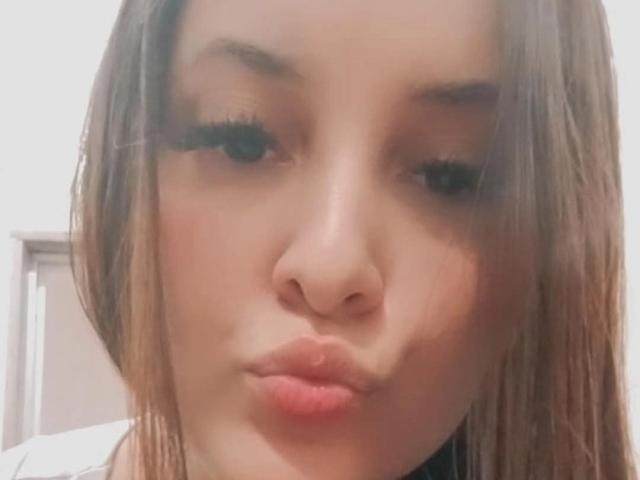 AngelyouAremine's pouty face with full, slightly parted pink lips, long brown hair, and thick, long, black eyelashes. Her skin is light with a subtle, natural glow.